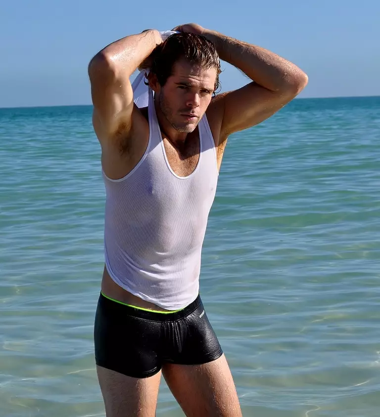 El impactante modelo estadounidense Jake Jensen es “Water Boy” en la nueva sesión de playa capturada por Rick Araujo. Jake lleva trajes de baño de 2XIST.