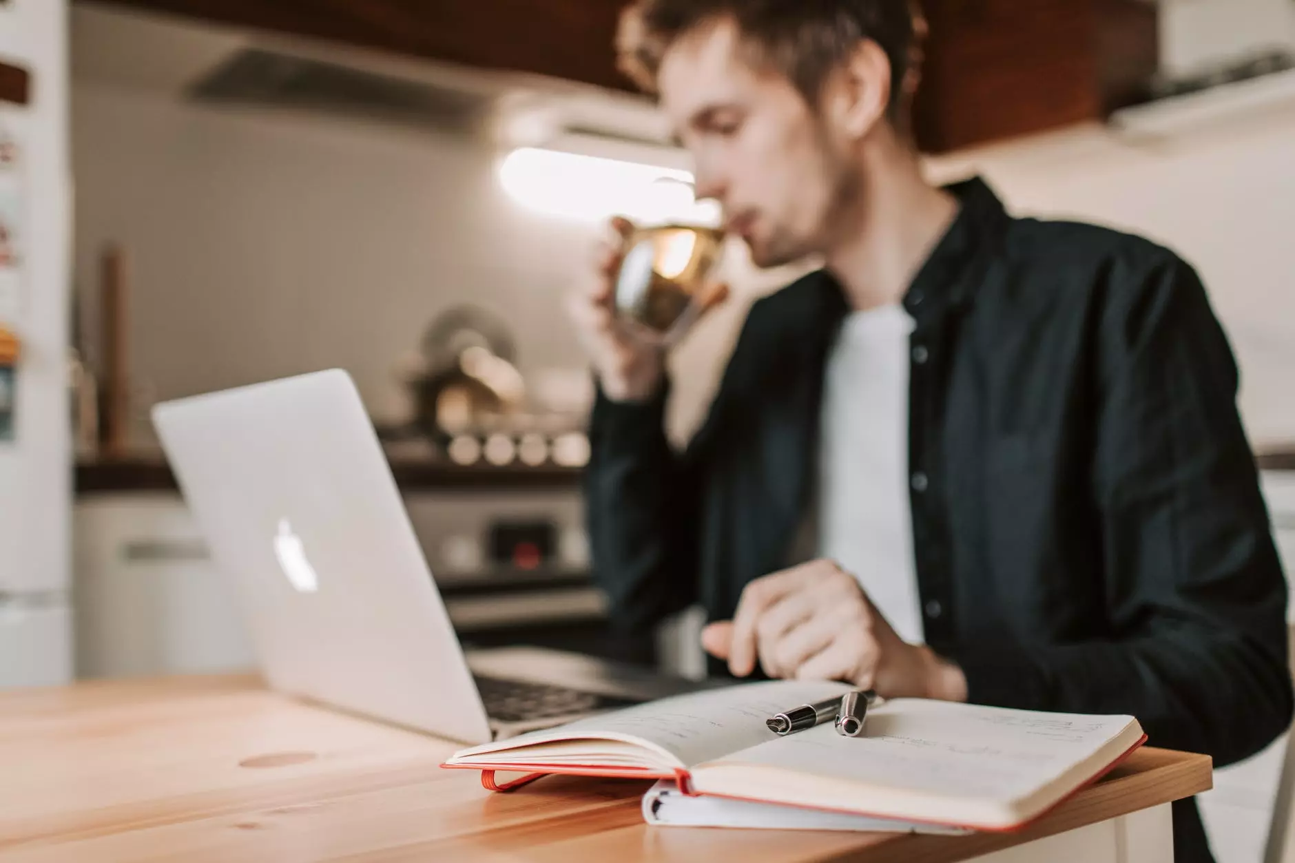 uprawa mężczyzna freelancer pije wodę podczas oglądania laptopa w kuchni