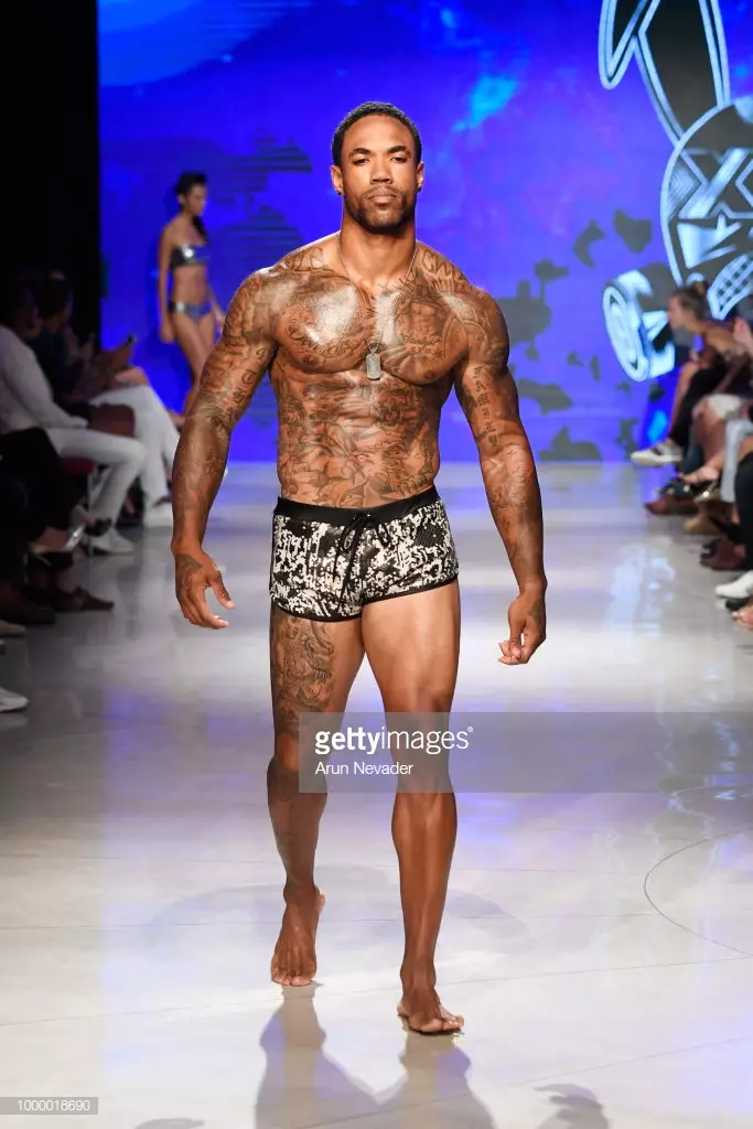 Модели Mister Triple X дар Ҳафтаи шиноварии Miami Swim, ки аз ҷониби Art Hearts Fashion Swim/Resort 2018/19 дар Форуми Фаена 15 июли соли 2018 дар Майами Бич, Флорида сохта шудааст, мегузарад.