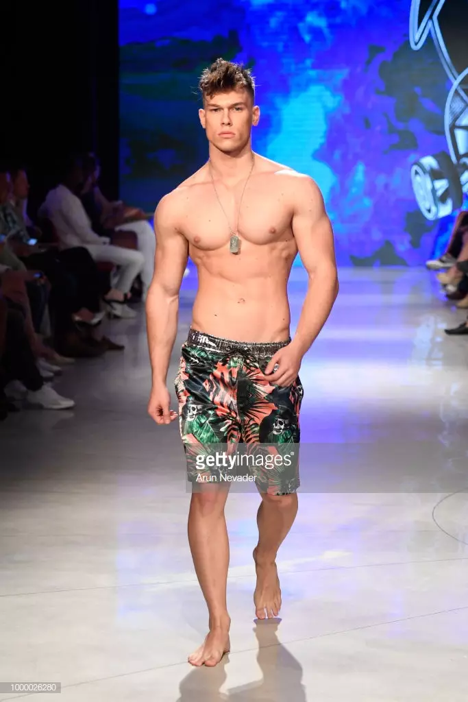 Модели Mister Triple X дар Ҳафтаи шиноварии Miami Swim, ки аз ҷониби Art Hearts Fashion Swim/Resort 2018/19 дар Форуми Фаена 15 июли соли 2018 дар Майами Бич, Флорида сохта шудааст, мегузарад.