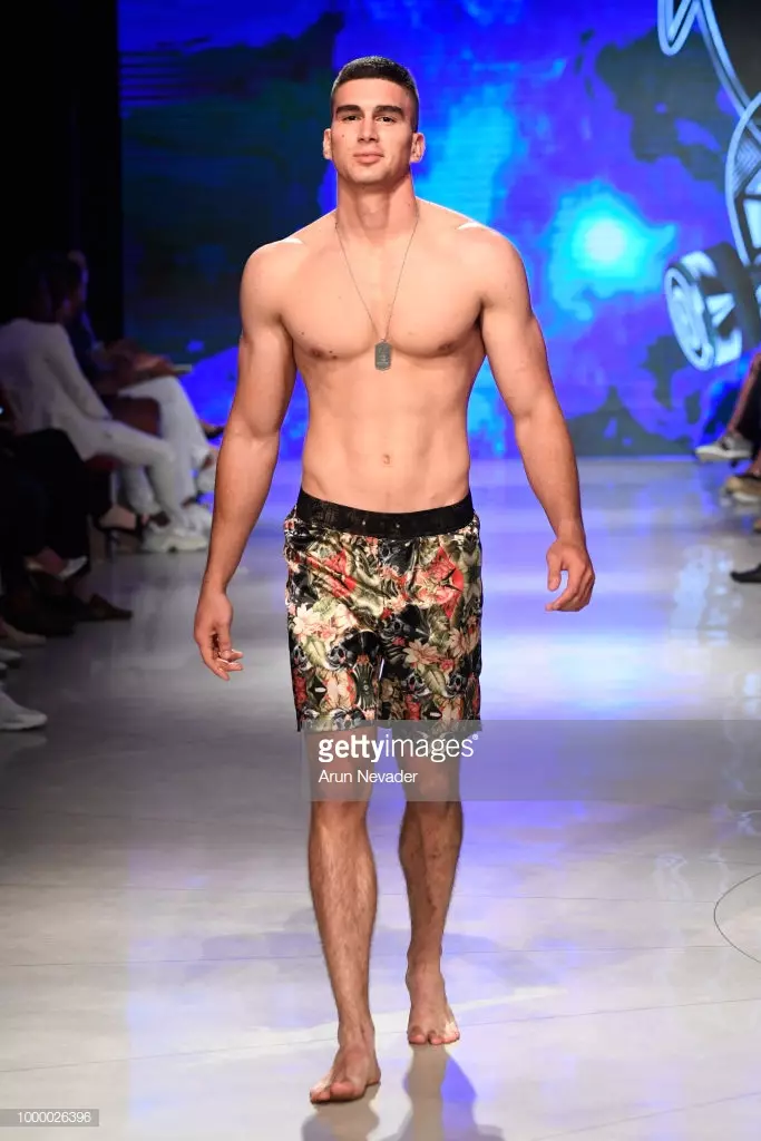 Модели Mister Triple X дар Ҳафтаи шиноварии Miami Swim, ки аз ҷониби Art Hearts Fashion Swim/Resort 2018/19 дар Форуми Фаена 15 июли соли 2018 дар Майами Бич, Флорида сохта шудааст, мегузарад.