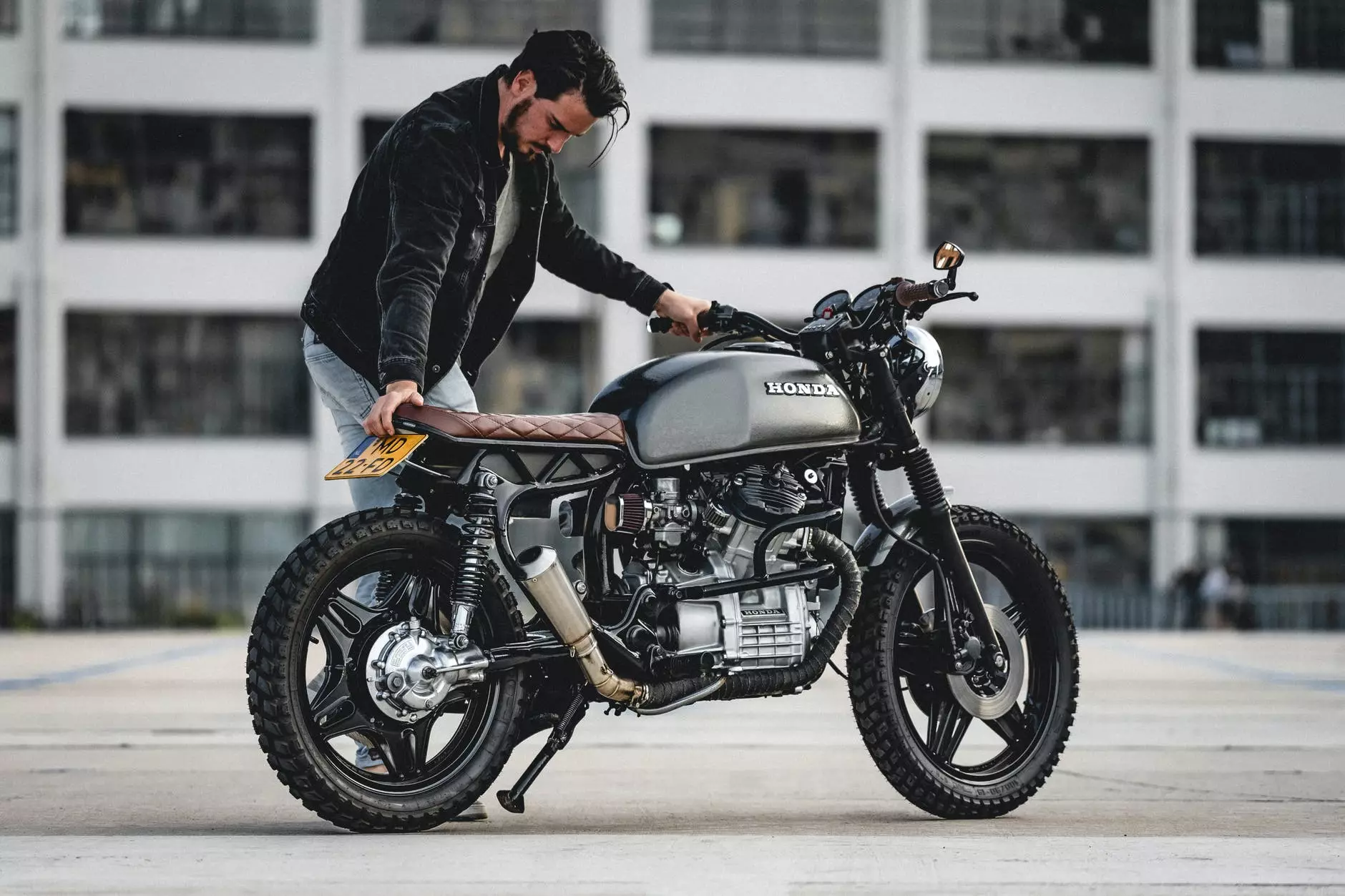 fotografie cu focalizare selectivă a unui bărbat în jachetă neagră parcare motocicletă neagră honda cafe racer. Fotografie de Gijs Coolen pe Pexels.com