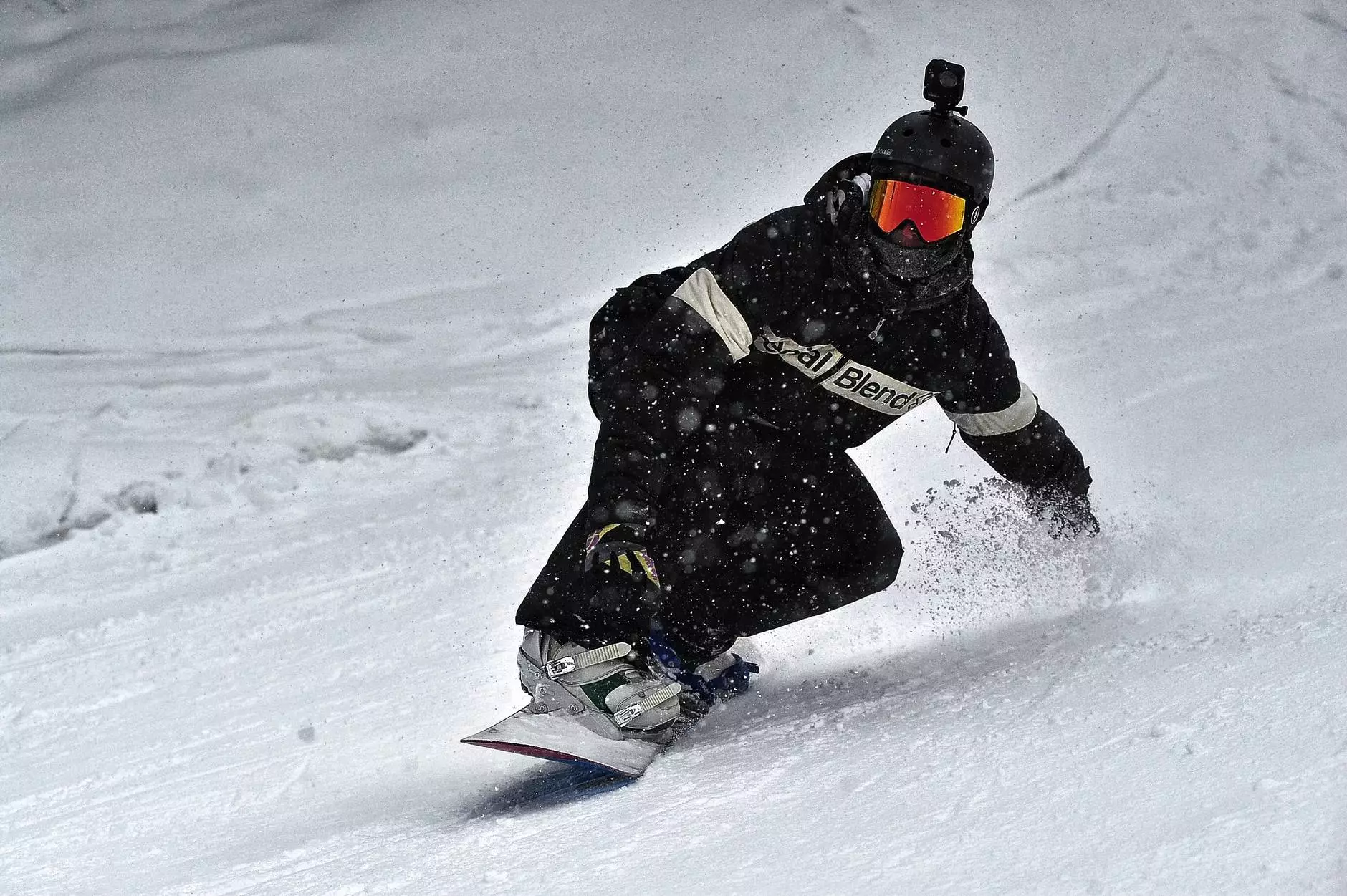 persoa con chaqueta negra e pantalóns negros montando en snowboard