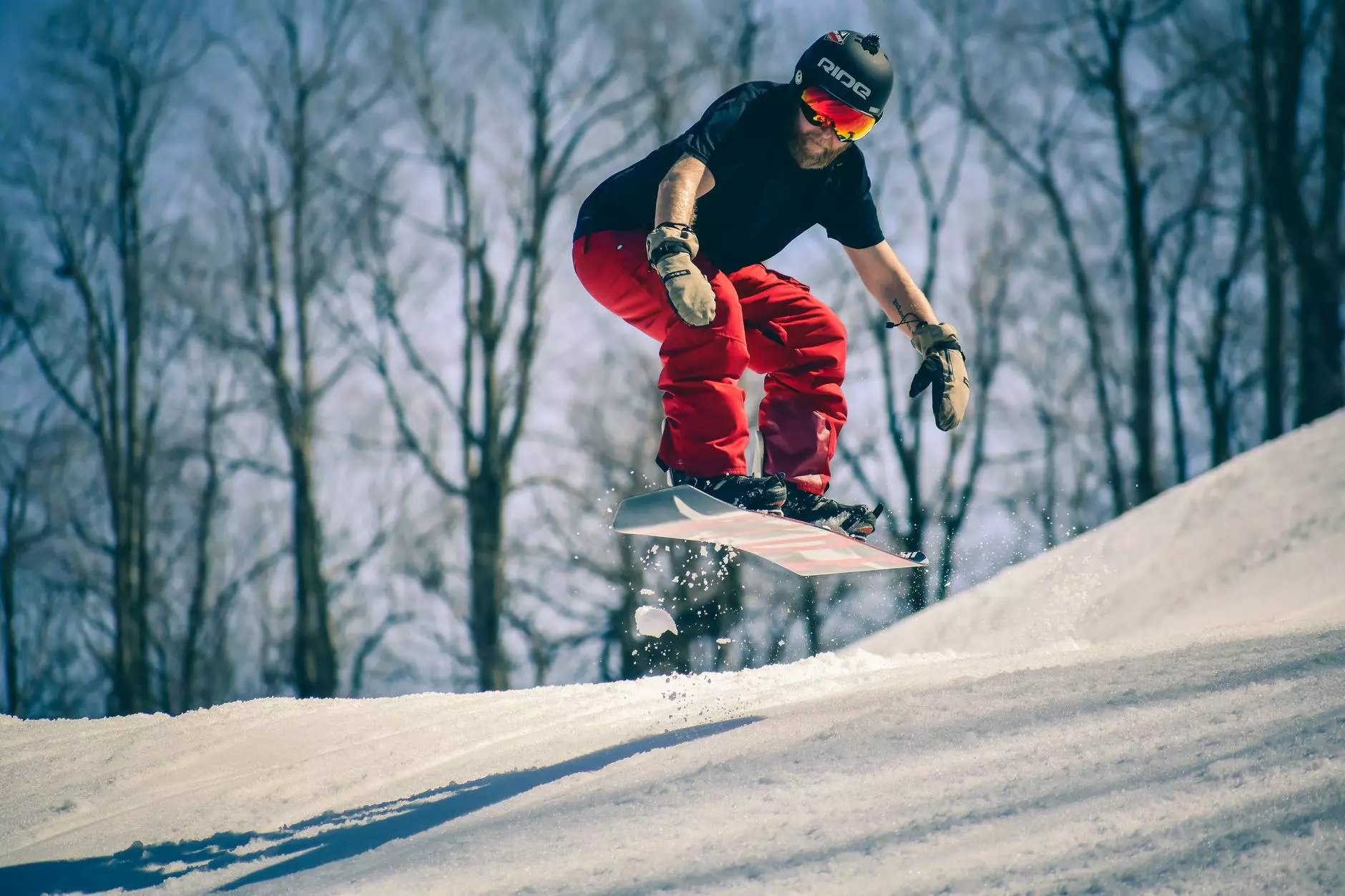 lalaki tunggang dina snowboard di pertengahan hawa luncat