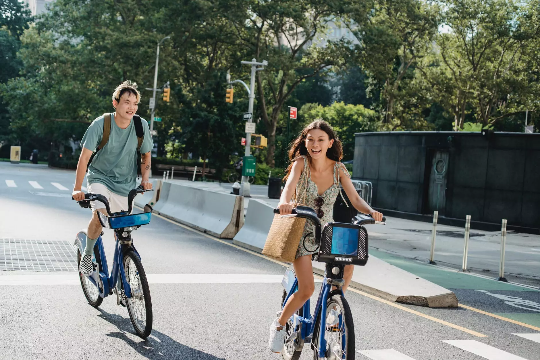 日光の下で街の通りで自転車に乗る前向きな友達