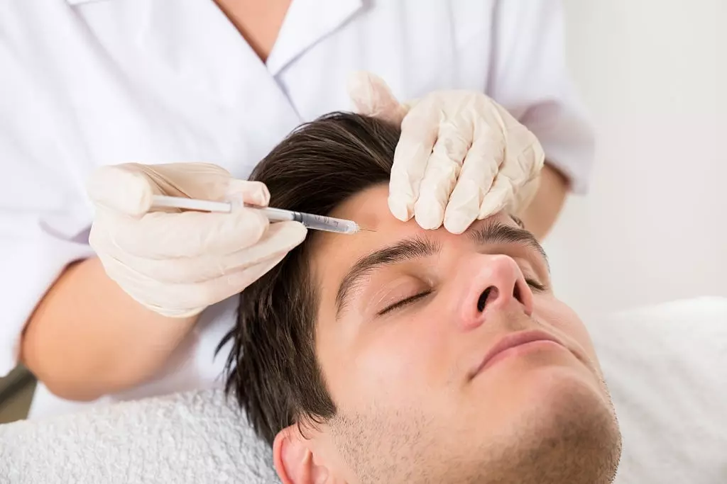 Hombre joven con tratamiento de Botox en la clínica de belleza