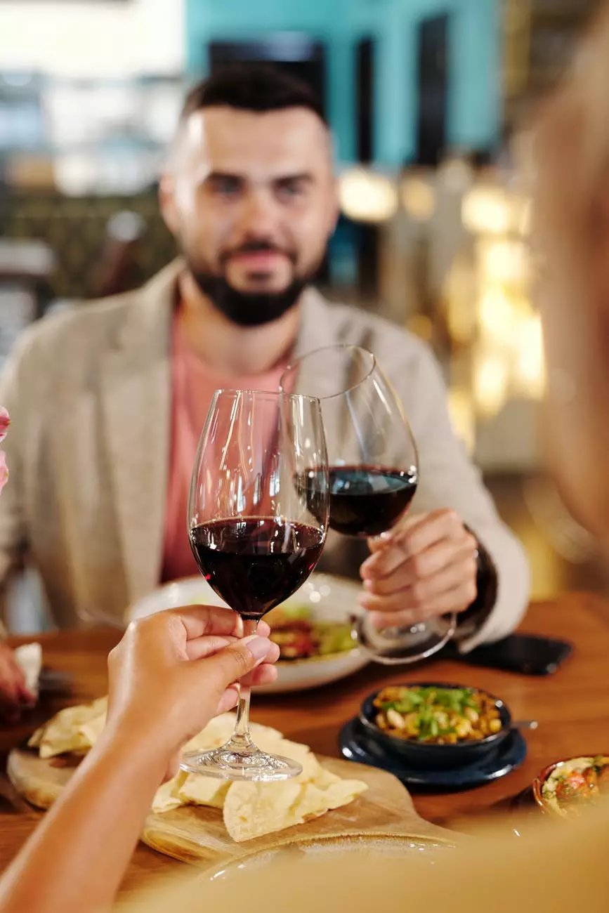 muškarac u sivom blejzeru koji drži čašu za vino