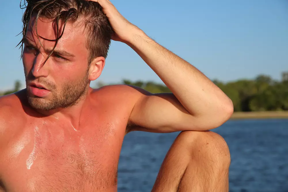 Il sorprendente ritratto di Andrew Lehmann in posa per una sessione di ritratti sulla spiaggia del fotografo Michael Del Buono catturato nell'elegante modella in bianco e nero di Charlie di MZ e Garçon Model.