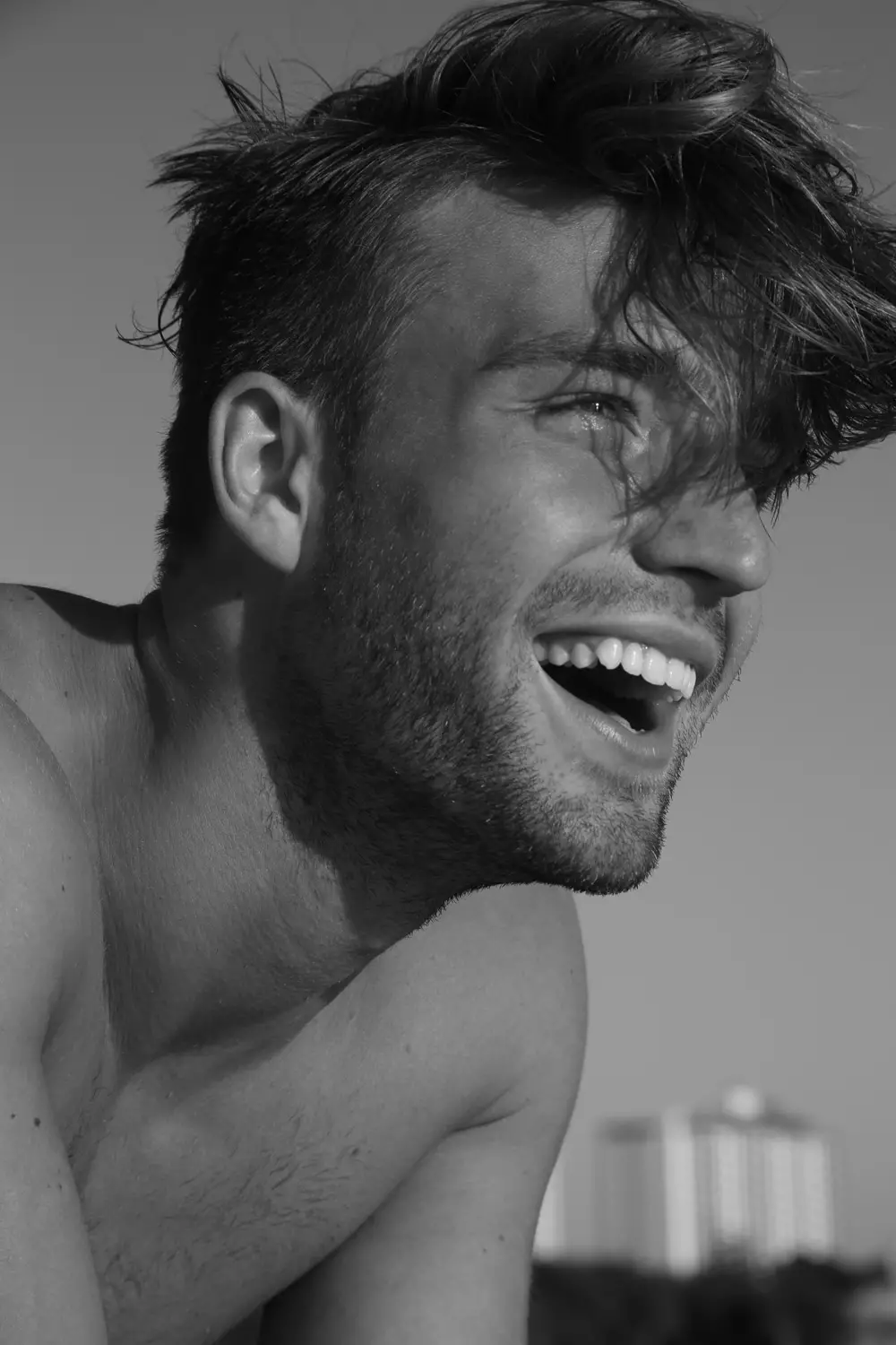 El sorprendente retrato de Andrew Lehmann posando para una sesión de retratos en la playa por el fotógrafo Michael Del Buono capturado con un elegante modelo en blanco y negro de Charlie por MZ y Garçon Model.